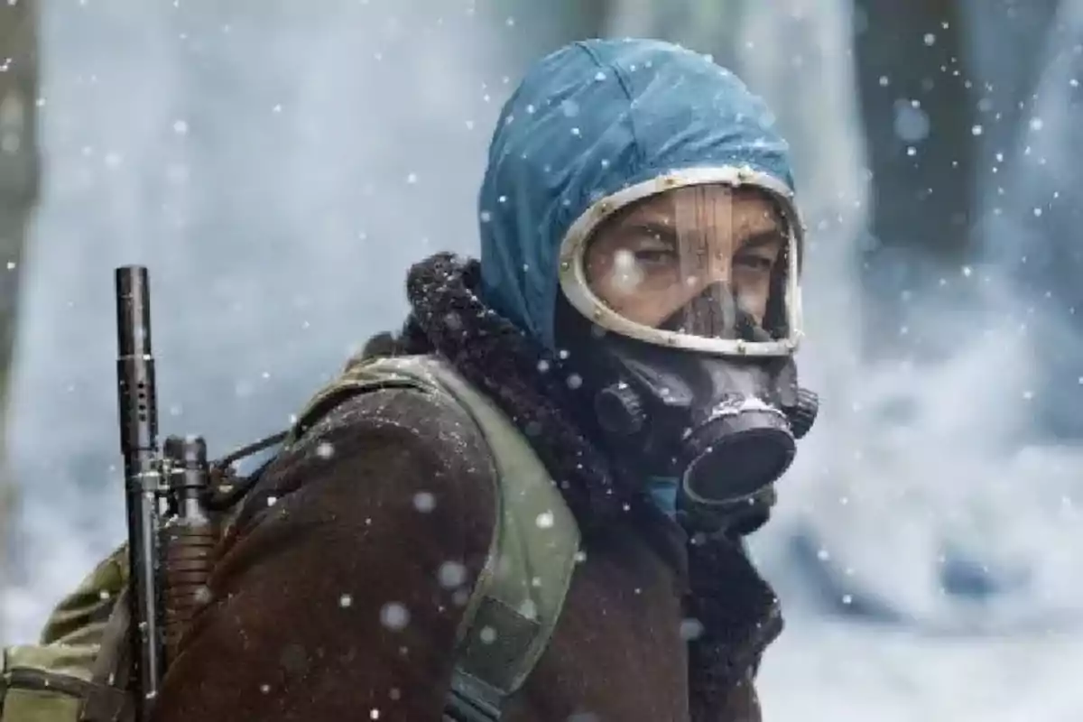 Person with a gas mask and blue hood in a snowy environment. Person with a gas mask and blue hood in a snowy environment.
