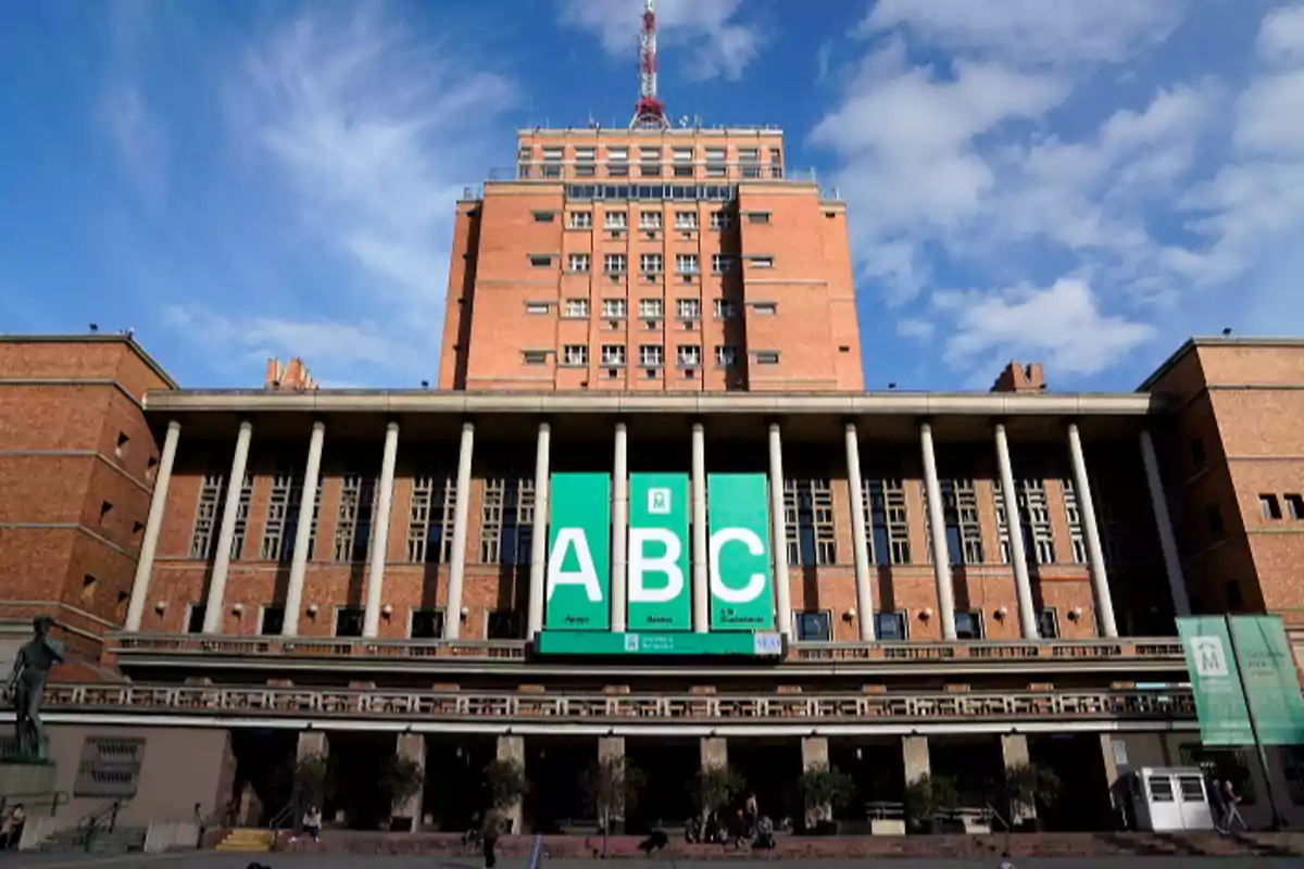 Edificio de ladrillo con columnas y un cartel verde grande que muestra las letras ABC. Edificio de ladrillo con columnas y un cartel verde grande que muestra las letras ABC.