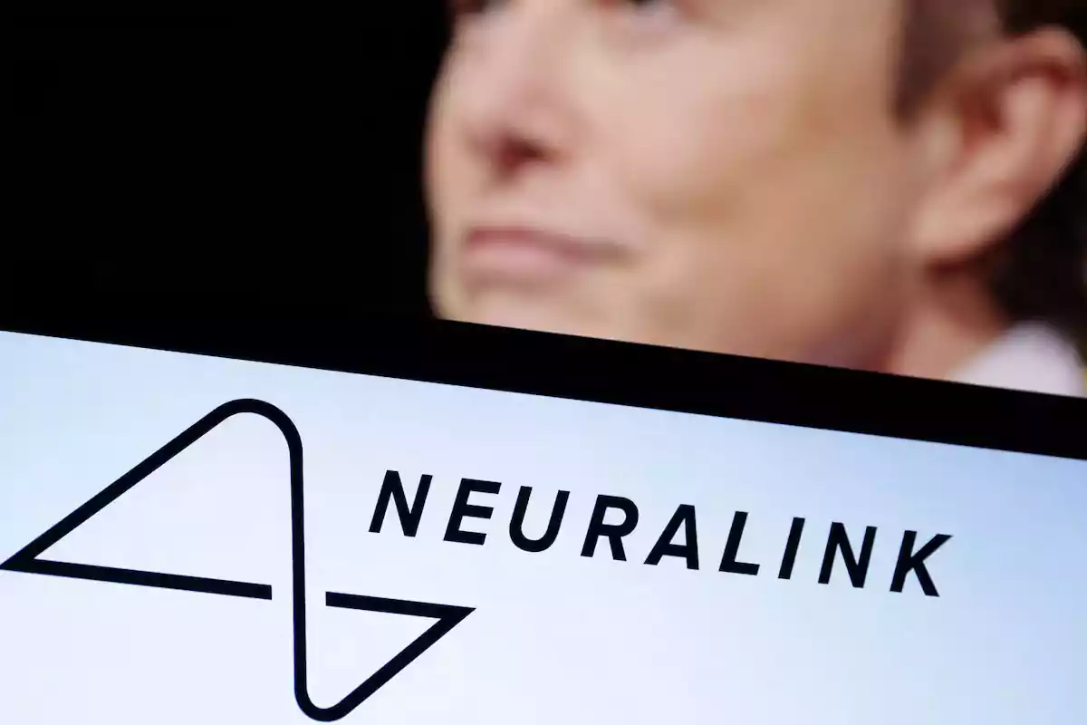 Un logotipo de Neuralink en primer plano con una figura desenfocada en el fondo. Un logotipo de Neuralink en primer plano con una figura desenfocada en el fondo.