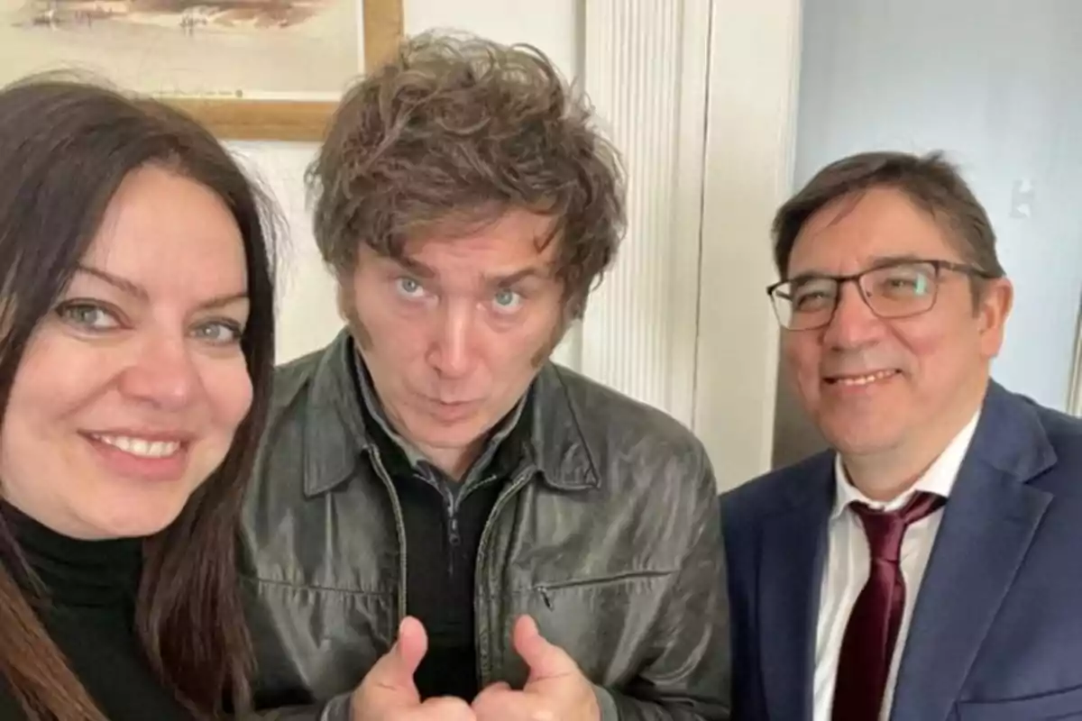 Tres personas posando para una foto sonrientes y con gestos amigables en un ambiente interior.