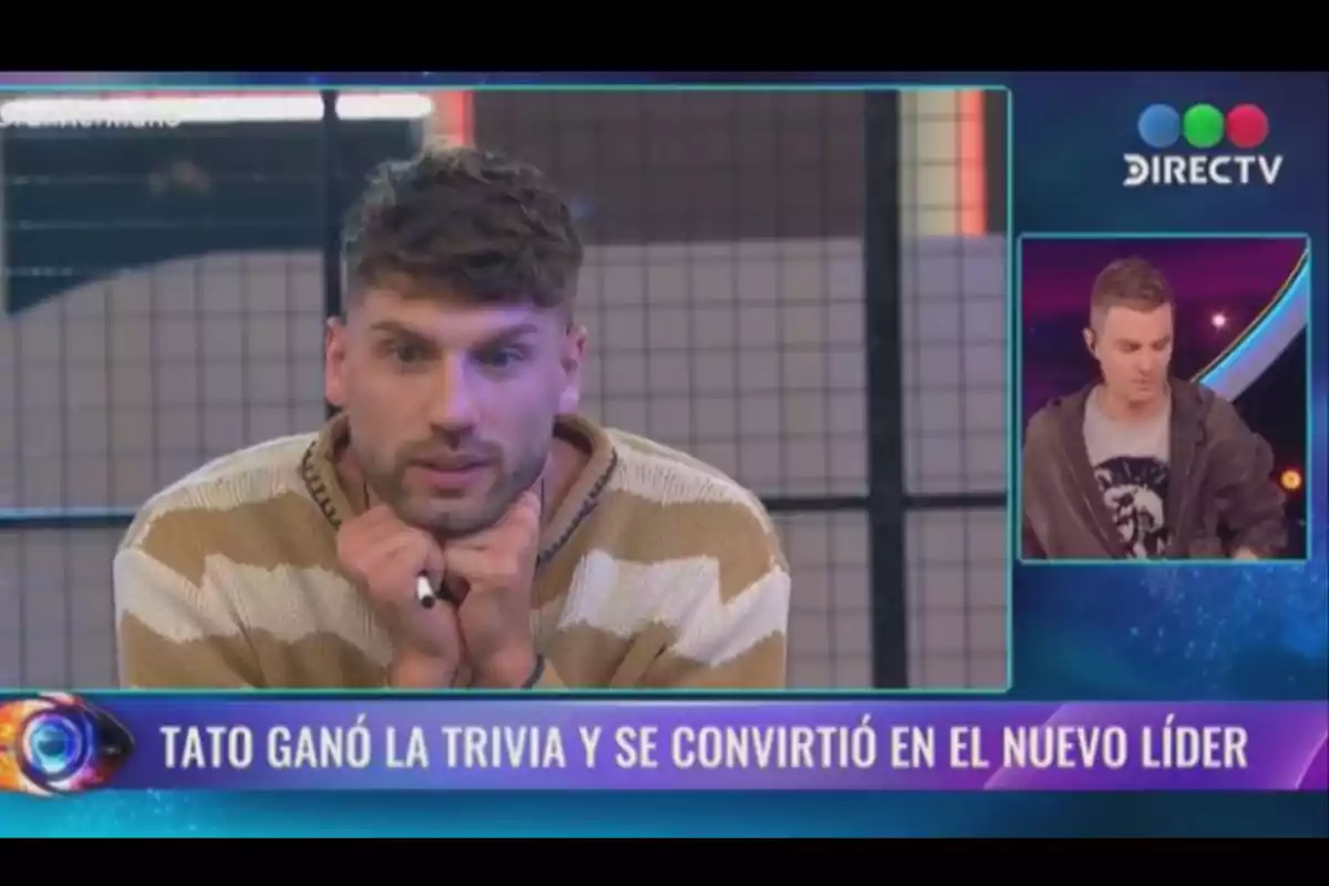 A man in a beige and white sweater appears thoughtful on a television show while the screen announces that Tato won the trivia and became the new leader. A man in a beige and white sweater appears thoughtful on a television show while the screen announces that Tato won the trivia and became the new leader.