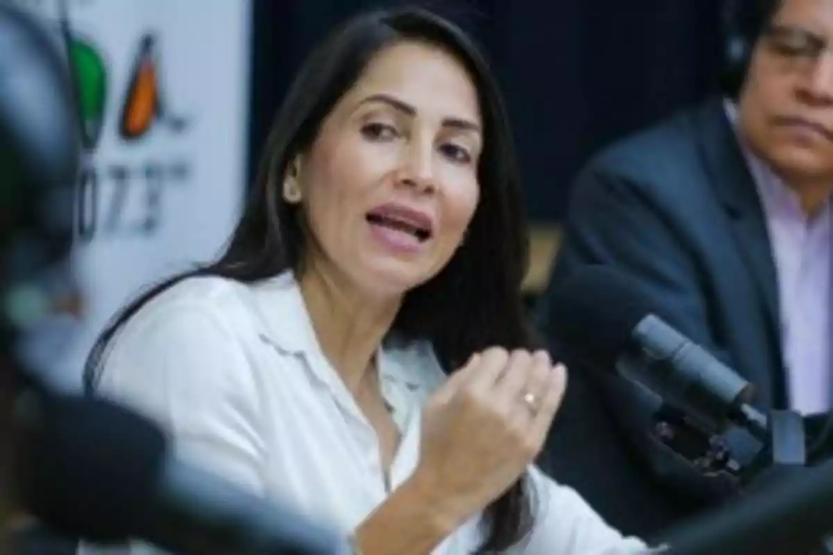 Una mujer hablando en un micrófono durante una conferencia o entrevista. Una mujer hablando en un micrófono durante una conferencia o entrevista.
