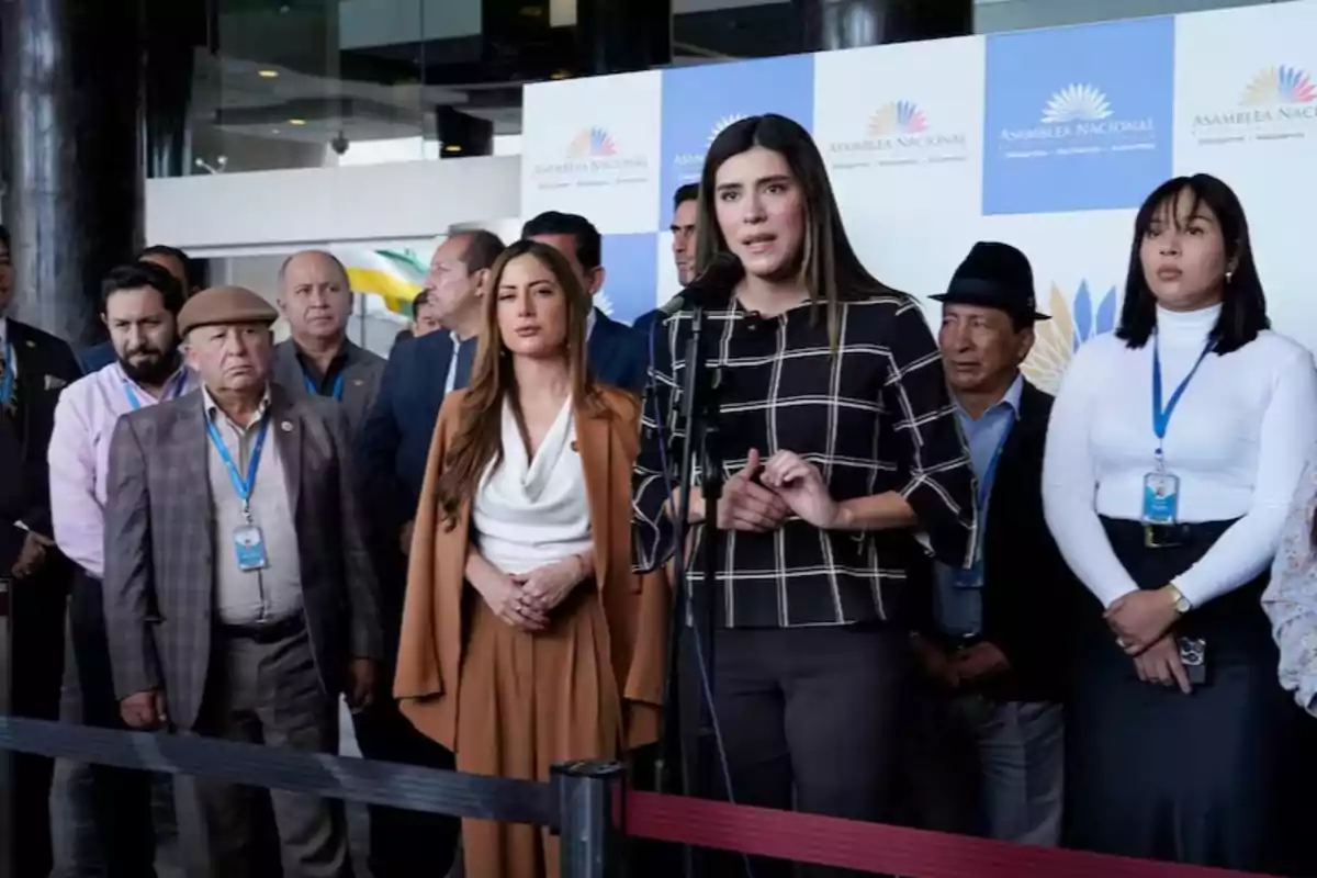 Un grupo de personas en una conferencia de prensa frente a un fondo con el logotipo de la Asamblea Nacional.