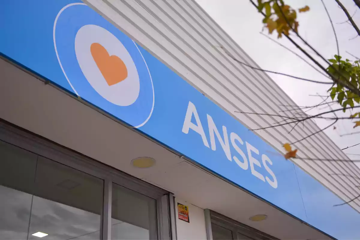 Fachada de un edificio de ANSES con un cartel azul y un logotipo de corazón.