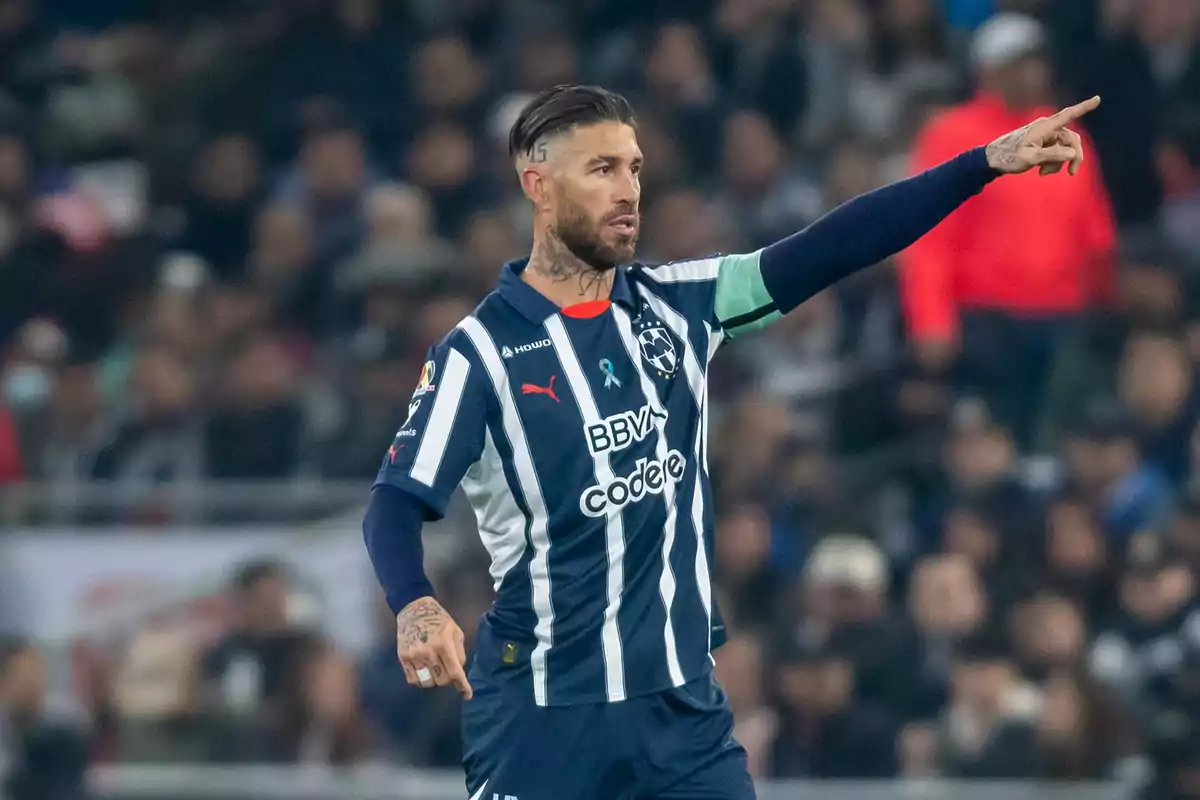 Soccer player in a blue and white striped uniform pointing to the right during a match Soccer player in a blue and white striped uniform pointing to the right during a match