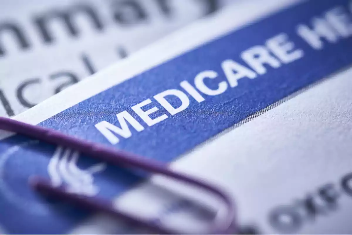 Documento de Medicare con un clip morado sobre una superficie impresa. Documento de Medicare con un clip morado sobre una superficie impresa.
