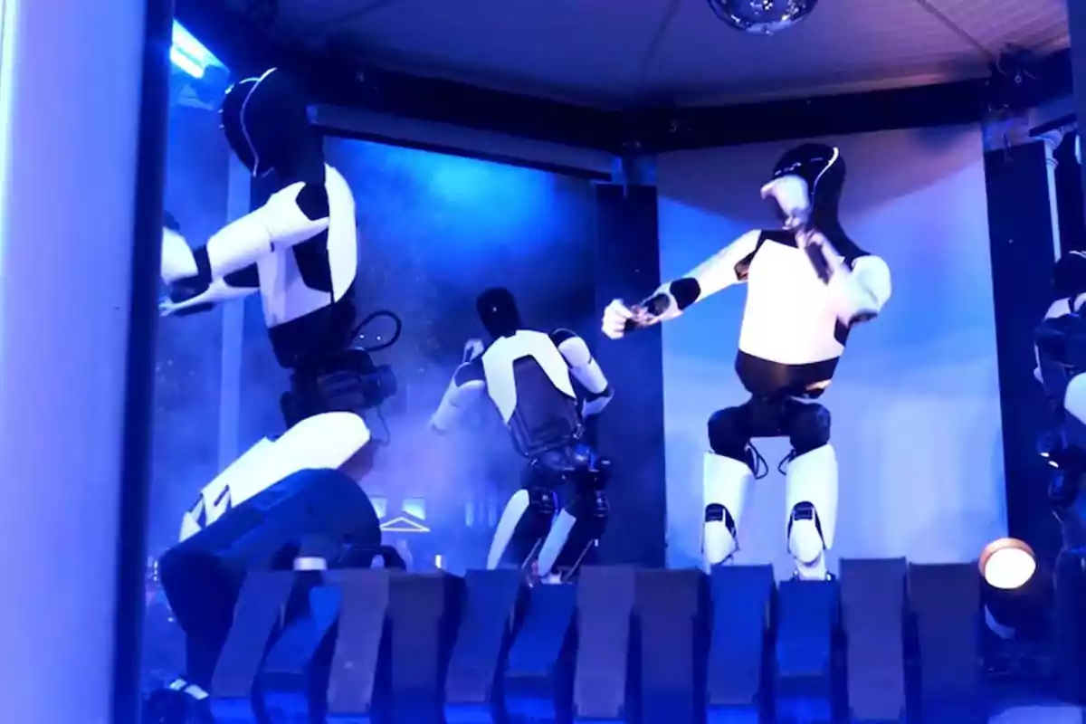 Robots humanoides bailando en un escenario iluminado con luces azules. Robots humanoides bailando en un escenario iluminado con luces azules.