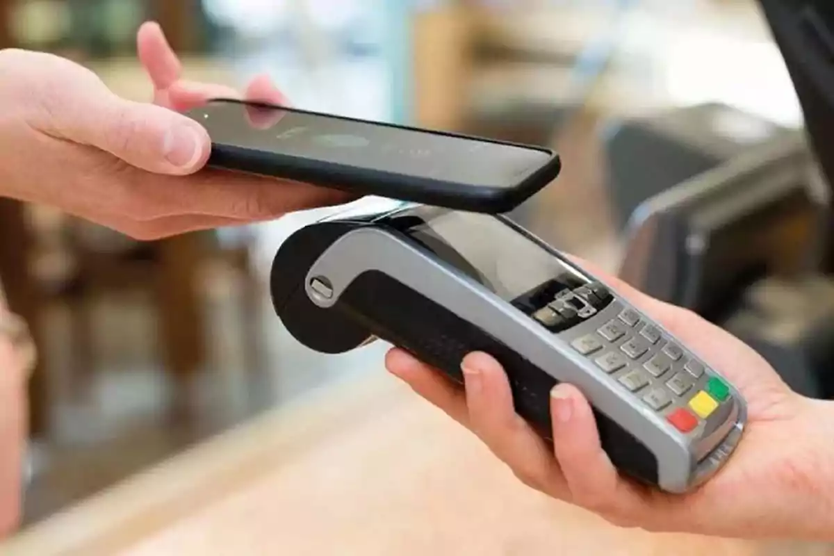Person making a payment with a mobile phone using contactless payment technology at a point-of-sale terminal. Person making a payment with a mobile phone using contactless payment technology at a point-of-sale terminal.