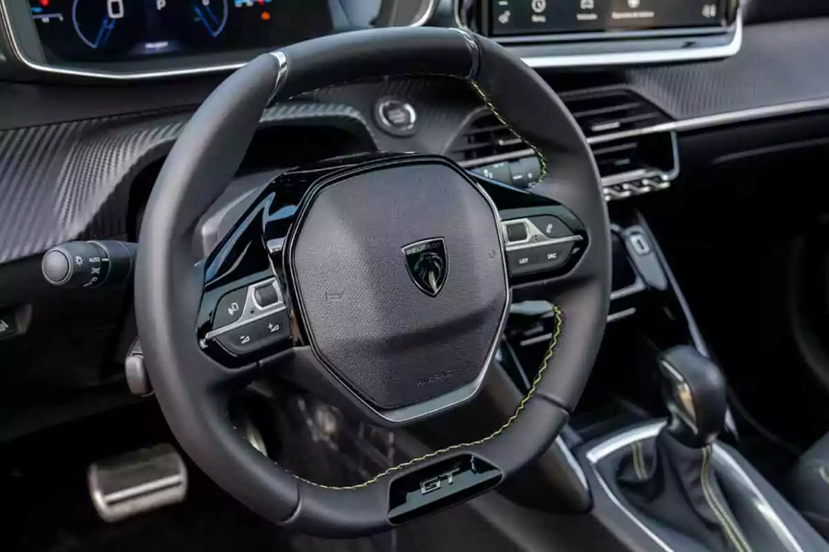 Volante de automóvil Peugeot con detalles en costura amarilla y controles integrados en el interior moderno del vehículo Volante de automóvil Peugeot con detalles en costura amarilla y controles integrados en el interior moderno del vehículo