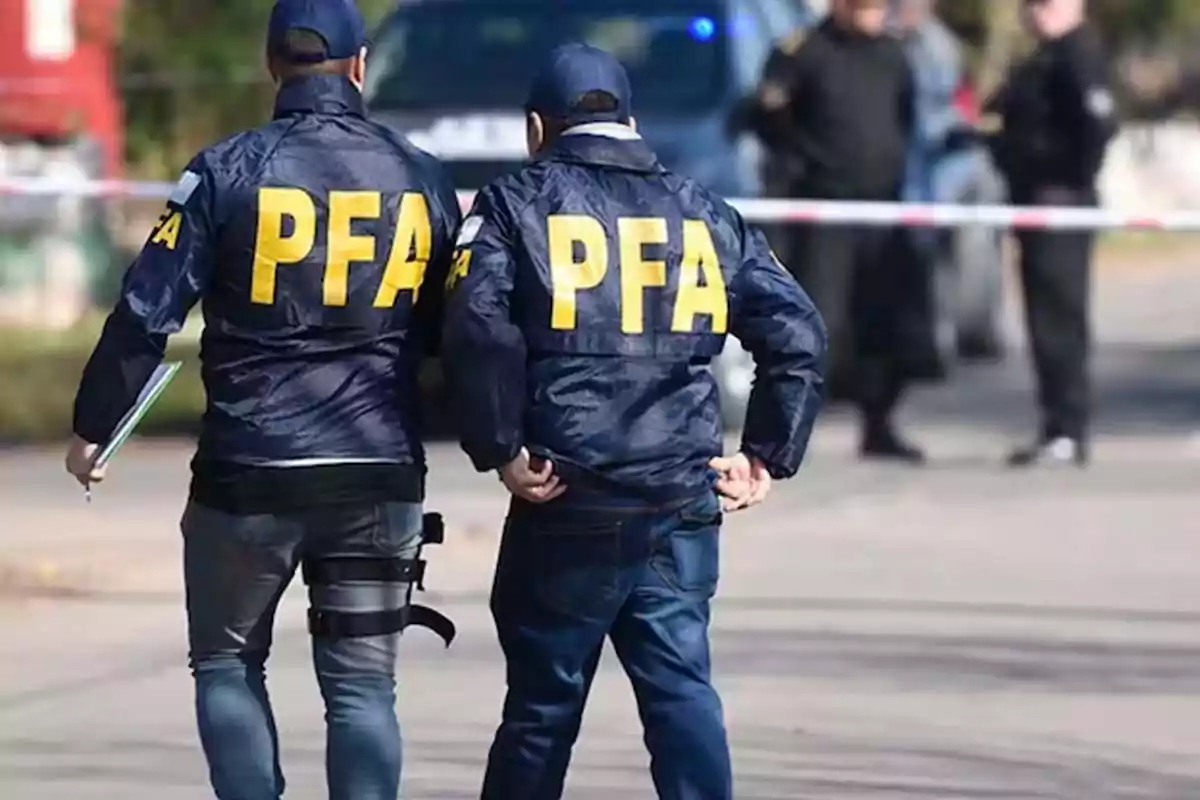 Dos agentes de la policía con chaquetas que tienen las letras Dos agentes de la policía con chaquetas que tienen las letras