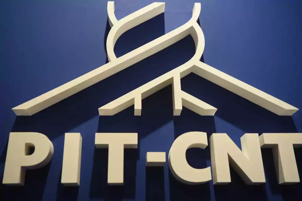 Logotipo de PIT-CNT en relieve sobre un fondo azul. Logotipo de PIT-CNT en relieve sobre un fondo azul.