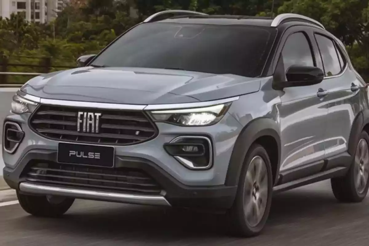 Un SUV Fiat Pulse de color gris circulando por una carretera con árboles al fondo.