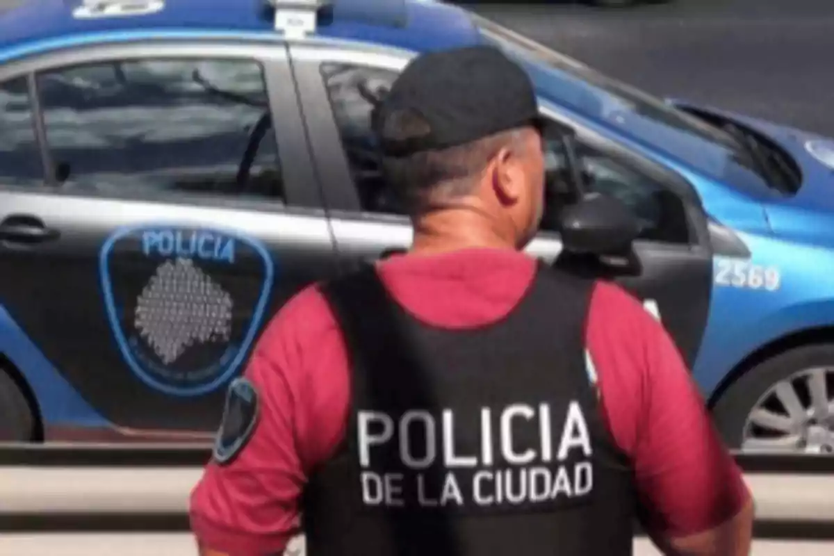 Un oficial de policía de la ciudad de espaldas con un chaleco que dice 