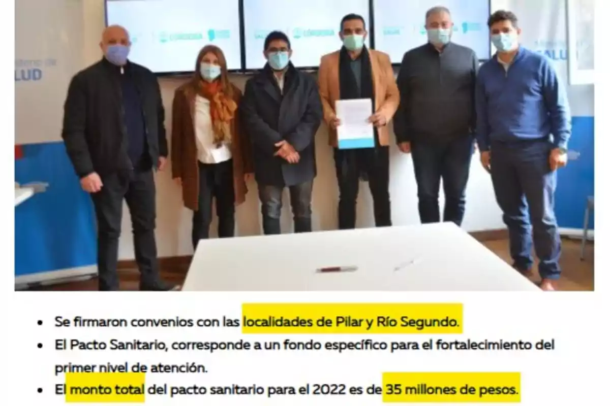 Six people wearing masks pose in an office next to a table, one of them holding a document, and at the bottom of the image there is highlighted text mentioning agreements with Pilar and Río Segundo and a total amount of 35 million pesos.