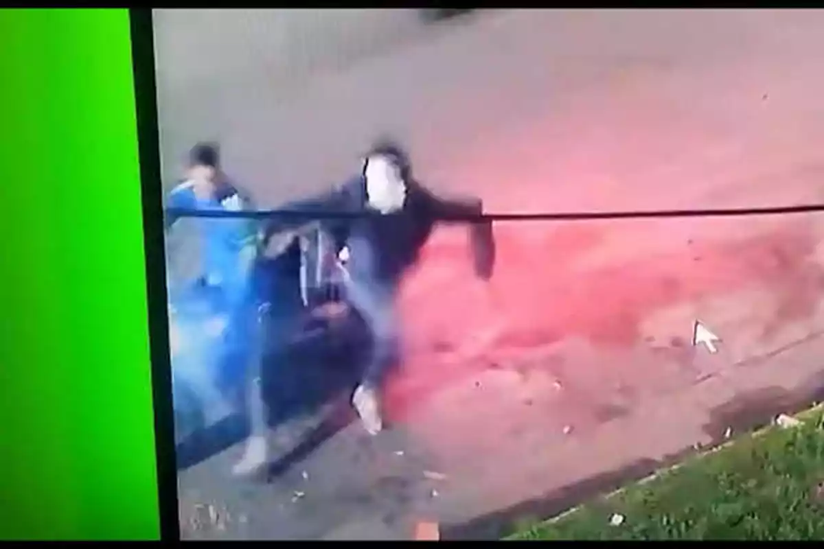 Dos personas corriendo en una calle, captadas por una cámara de seguridad, con un fondo verde a la izquierda y un resplandor rojo a la derecha. Dos personas corriendo en una calle, captadas por una cámara de seguridad, con un fondo verde a la izquierda y un resplandor rojo a la derecha.