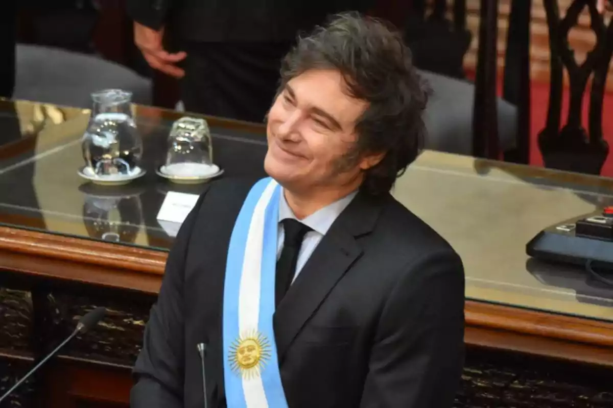 Persona con banda presidencial argentina sonriendo en un recinto oficial.