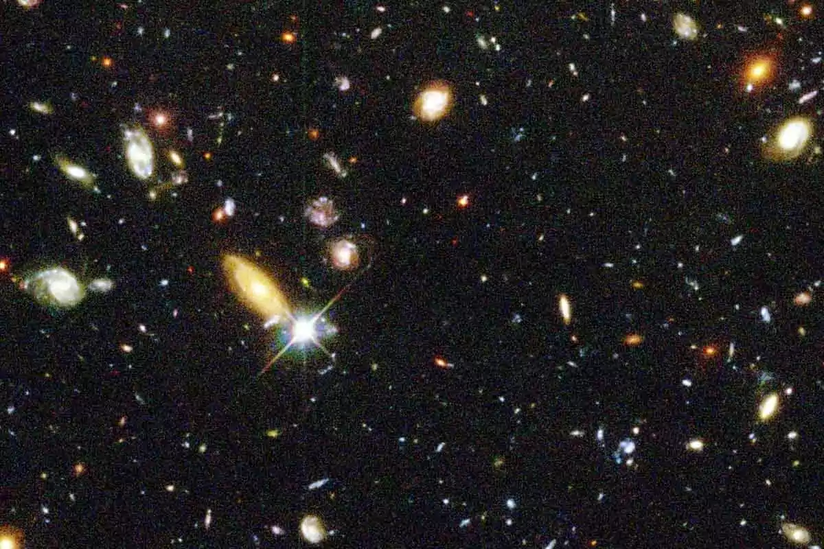 An image of deep space showing numerous galaxies of different shapes and colors against a dark background. An image of deep space showing numerous galaxies of different shapes and colors against a dark background.