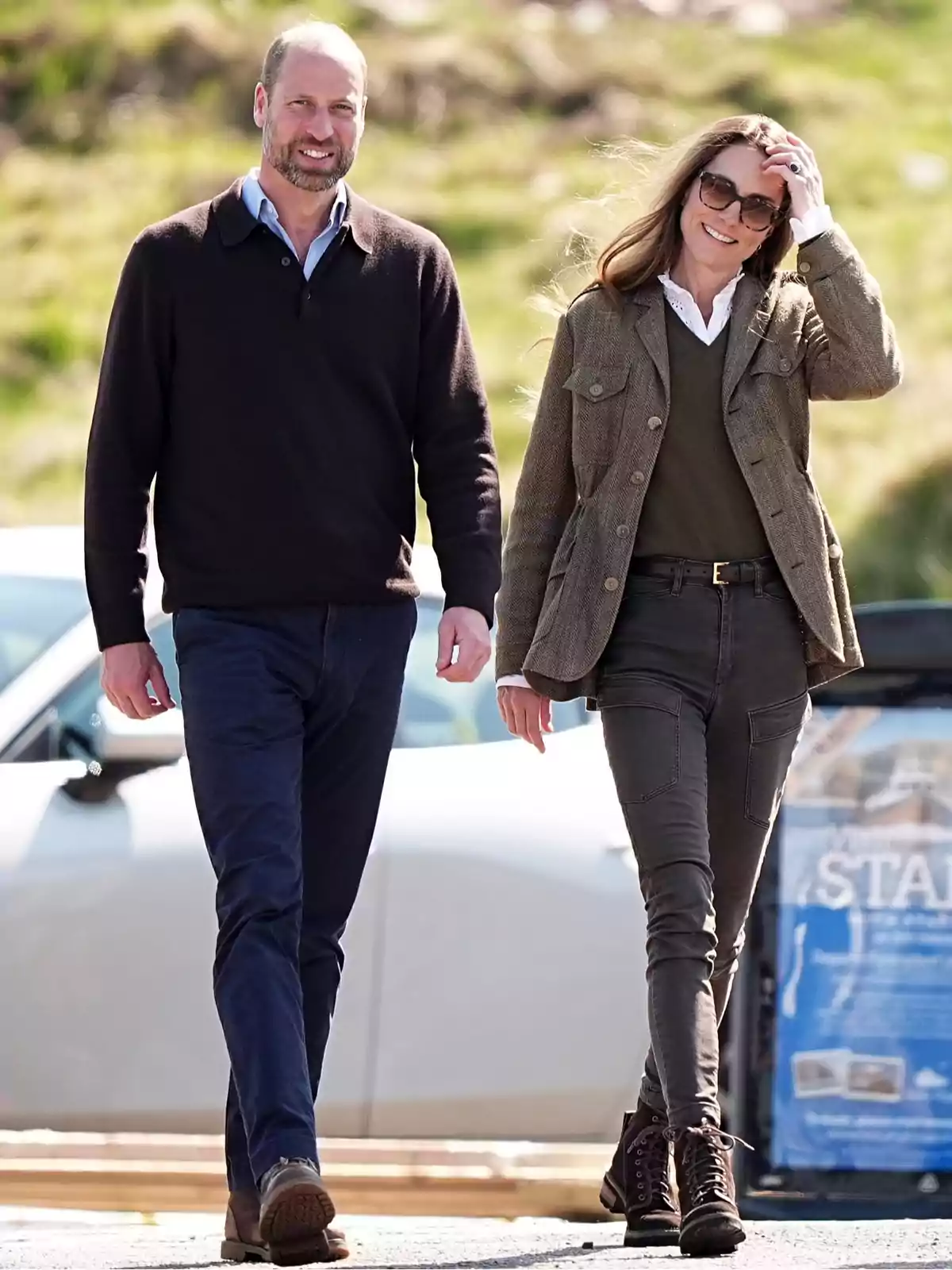 A couple walks outdoors smiling and enjoying a sunny day; both are dressed in casual clothes and look relaxed. A couple walks outdoors smiling and enjoying a sunny day; both are dressed in casual clothes and look relaxed.