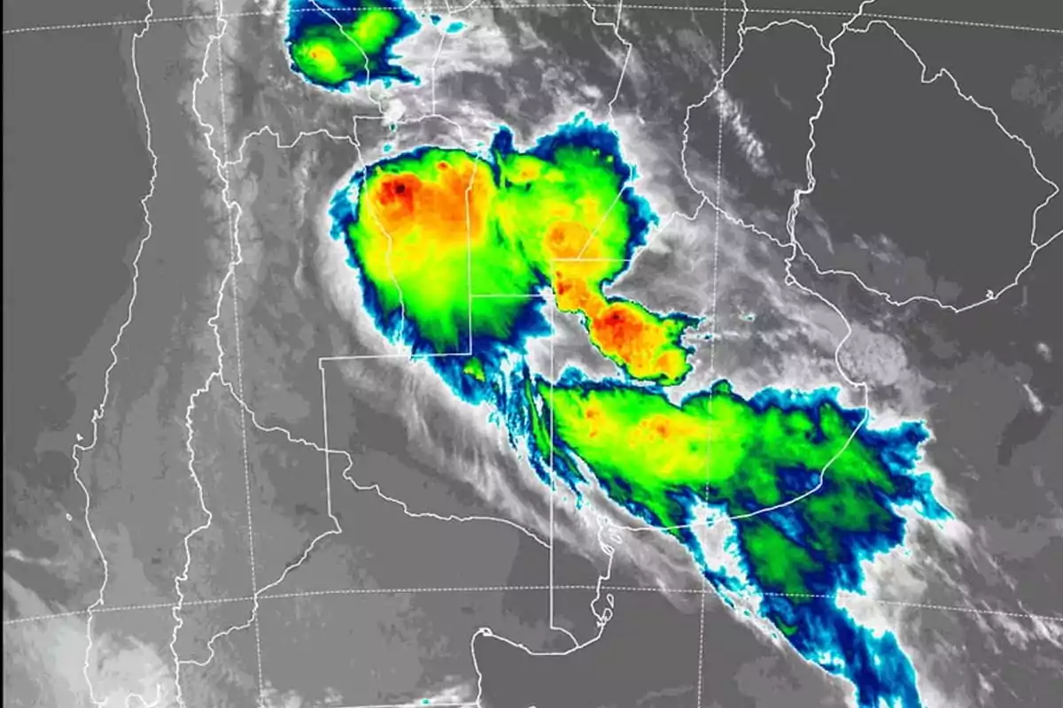 Imagen satelital que muestra un sistema de tormentas con áreas de alta intensidad en colores rojo y naranja sobre una región geográfica delimitada.