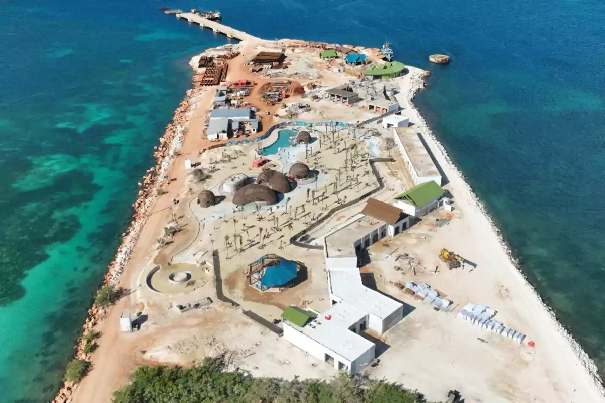 Vista aérea de una isla con construcciones en desarrollo junto al mar turquesa