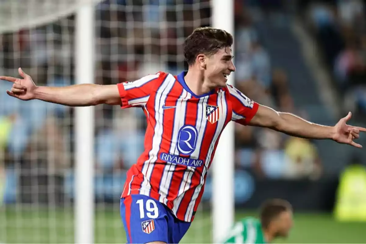 Futbolista del Atlético de Madrid celebrando un gol con los brazos extendidos en un estadio