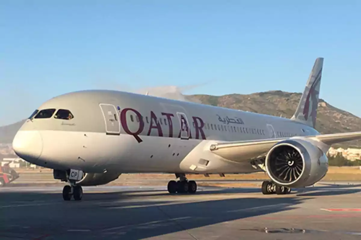 Un avión de Qatar Airways en la pista con montañas al fondo. Un avión de Qatar Airways en la pista con montañas al fondo.