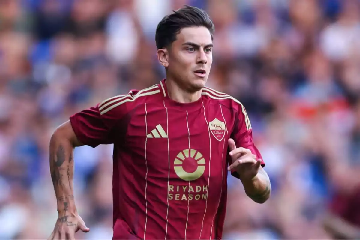 Soccer player in a red and gold Roma uniform running on the field during a match Soccer player in a red and gold Roma uniform running on the field during a match