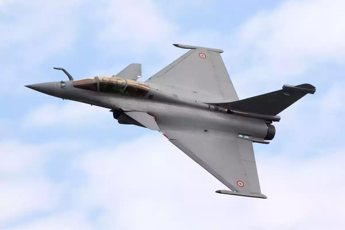 A fighter jet in flight against a blue sky background. A fighter jet in flight against a blue sky background.