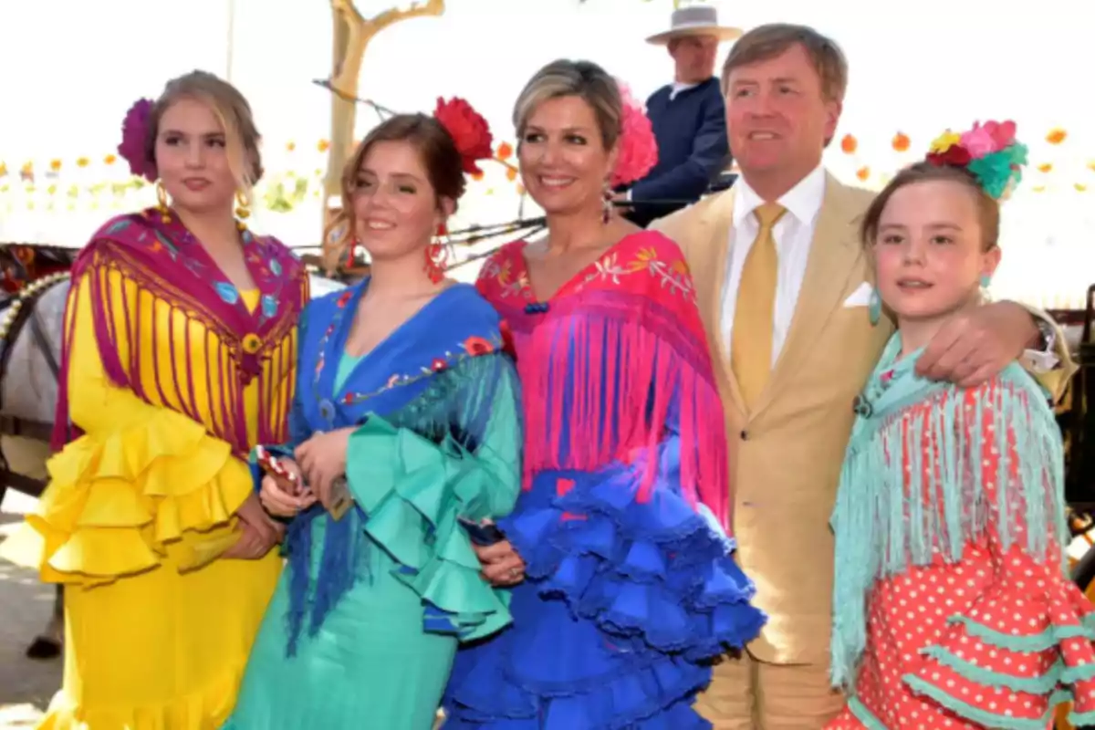 Un grupo de personas vestidas con trajes tradicionales coloridos posan juntas al aire libre durante un evento festivo. Un grupo de personas vestidas con trajes tradicionales coloridos posan juntas al aire libre durante un evento festivo.