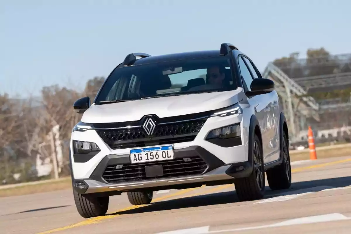 Un automóvil Renault blanco circulando por una carretera.