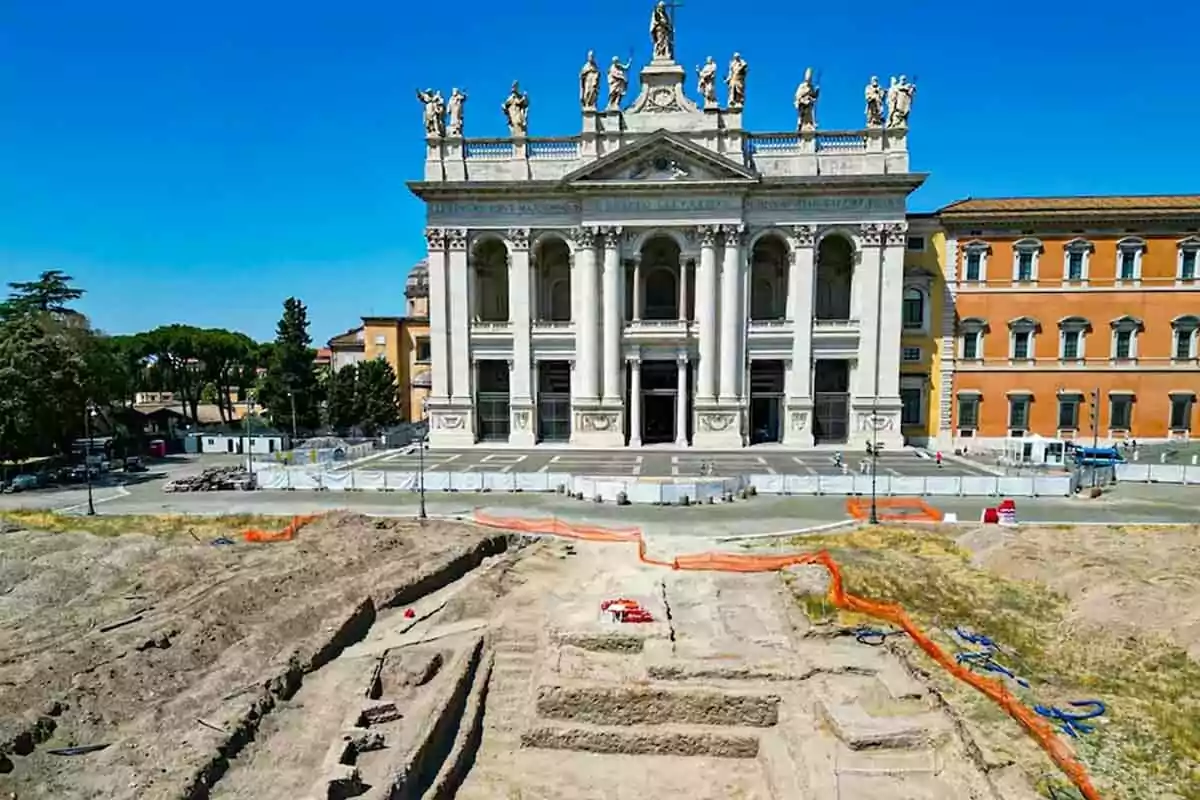 Excavación arqueológica frente a una iglesia histórica con estatuas en la parte superior y un cielo despejado. Excavación arqueológica frente a una iglesia histórica con estatuas en la parte superior y un cielo despejado.
