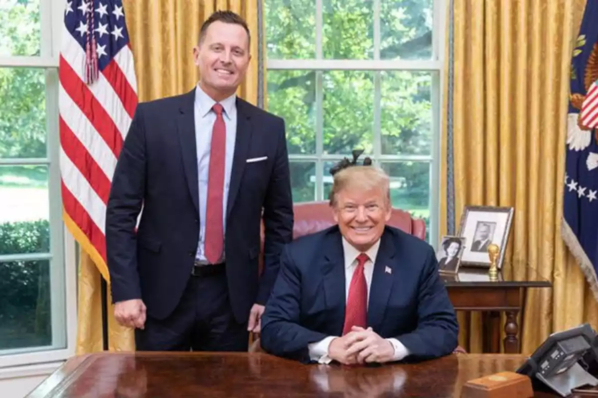 Two men in an office with golden curtains and a United States flag. Two men in an office with golden curtains and a United States flag.