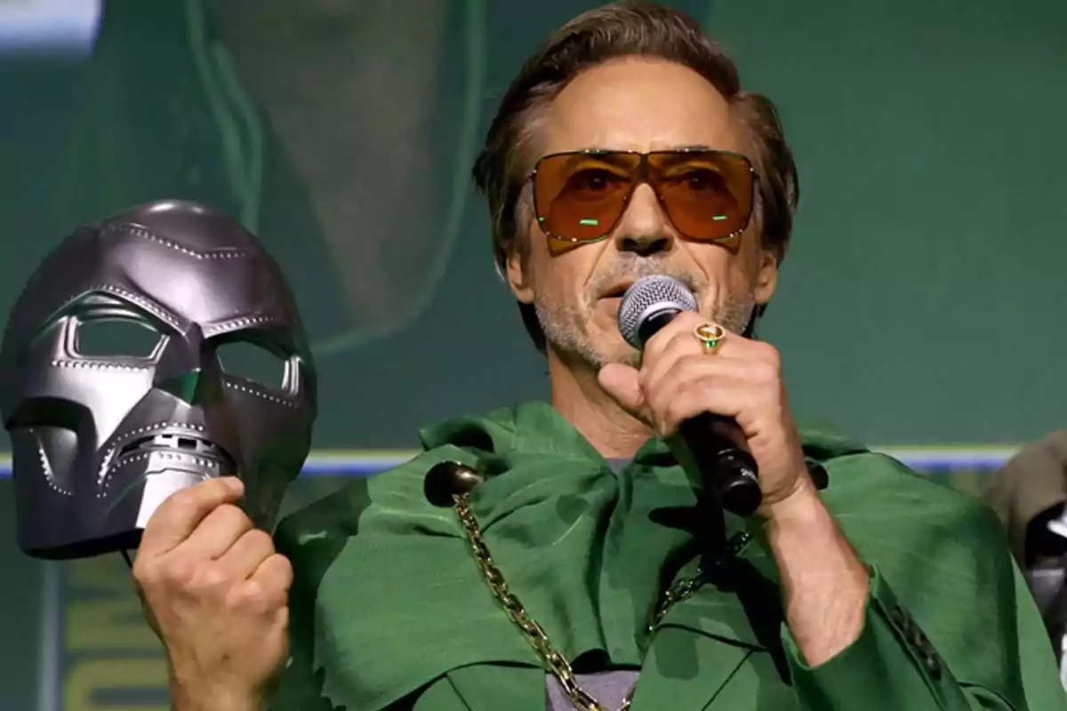 Man with dark glasses and a green cape holding a microphone and a metal mask Man with dark glasses and a green cape holding a microphone and a metal mask
