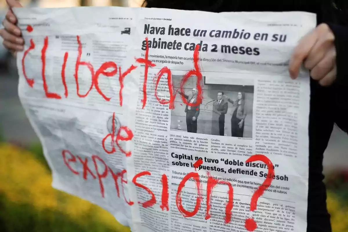 Persona sosteniendo un periódico con la frase Persona sosteniendo un periódico con la frase