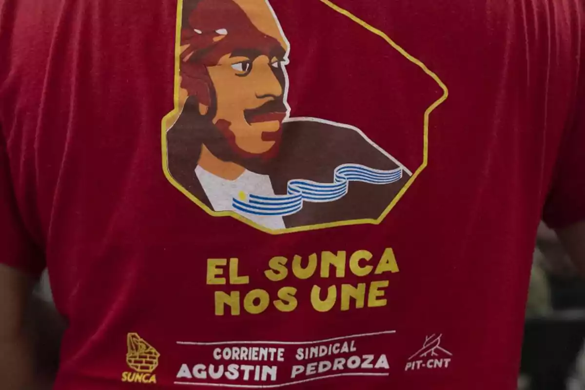 A red t-jersey with a design featuring a stylized portrait of a person and the text 