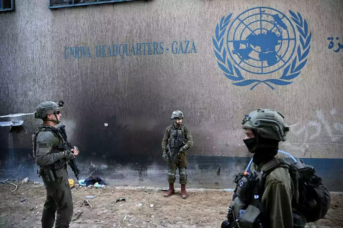 Soldados armados frente a un edificio con el logo de la ONU y la inscripción "UNRWA Headquarters - Gaza".