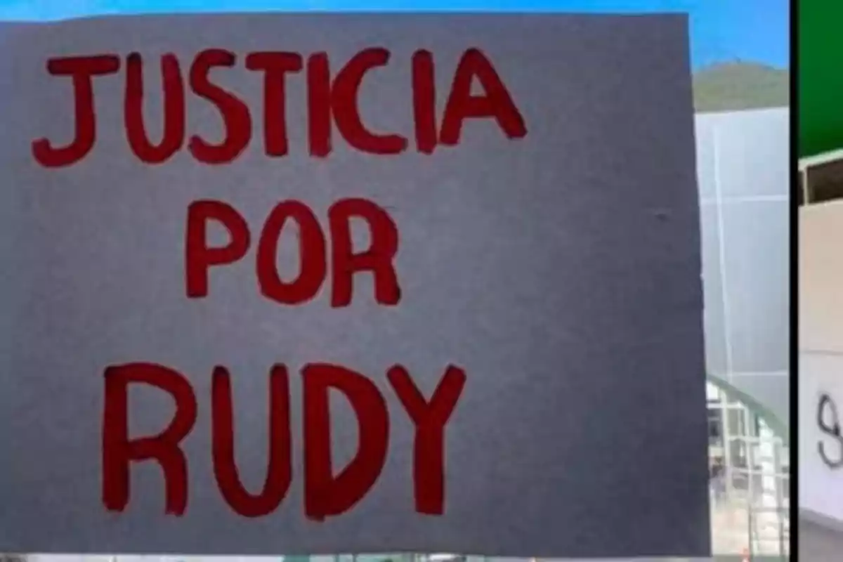 Un cartel con el texto "Justicia por Rudy" escrito en letras rojas sobre un fondo gris.