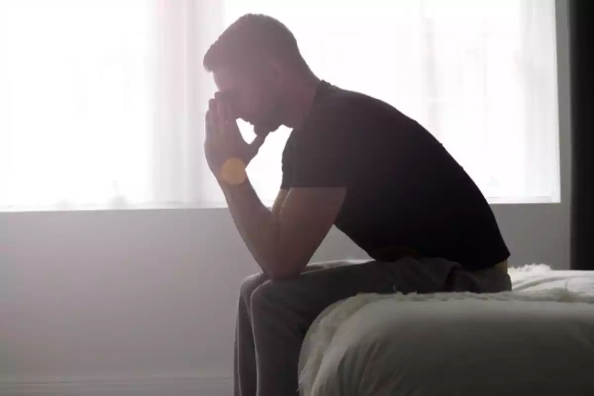 Man sitting on the bed with his hands on his face in a thoughtful attitude. Man sitting on the bed with his hands on his face in a thoughtful attitude.