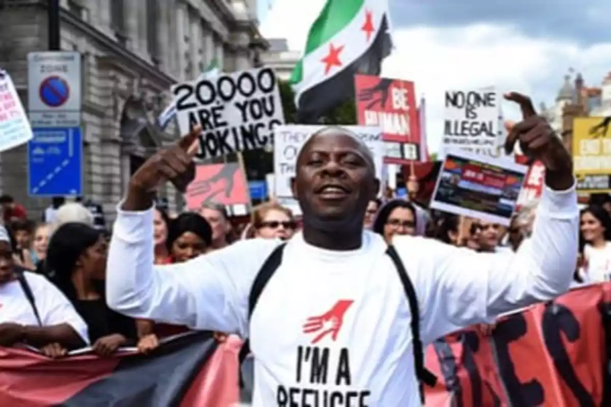 A group of people is participating in a demonstration holding signs with messages supporting refugees and human rights. A group of people is participating in a demonstration holding signs with messages supporting refugees and human rights.
