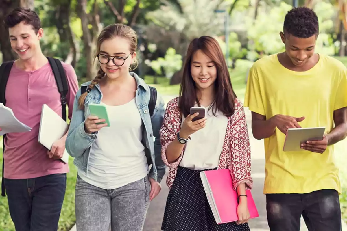A group of young people walking outdoors while using electronic devices. A group of young people walking outdoors while using electronic devices.