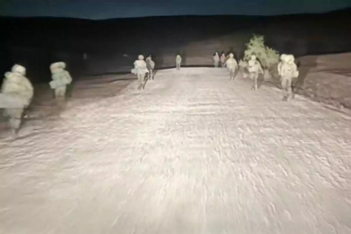 Un grupo de personas caminando por un camino de tierra en la noche.