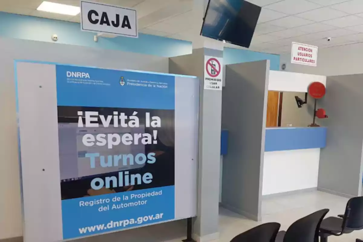 Oficina de atención al público con carteles que indican caja, turnos online y prohibido usar celular.