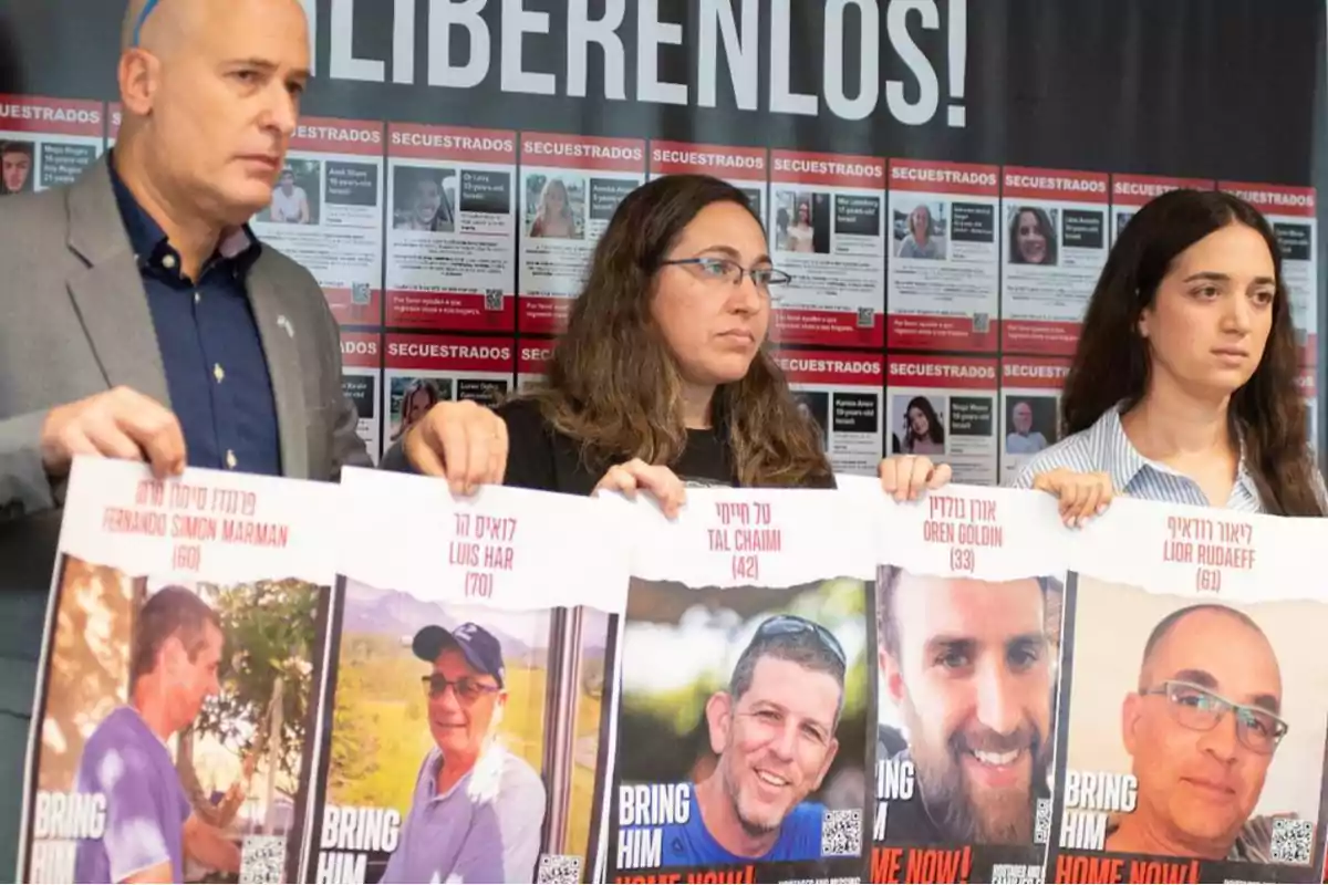 Un grupo de personas sostiene carteles con fotos y nombres de individuos desaparecidos frente a un fondo con más imágenes y la palabra "LIBÉRENLOS".