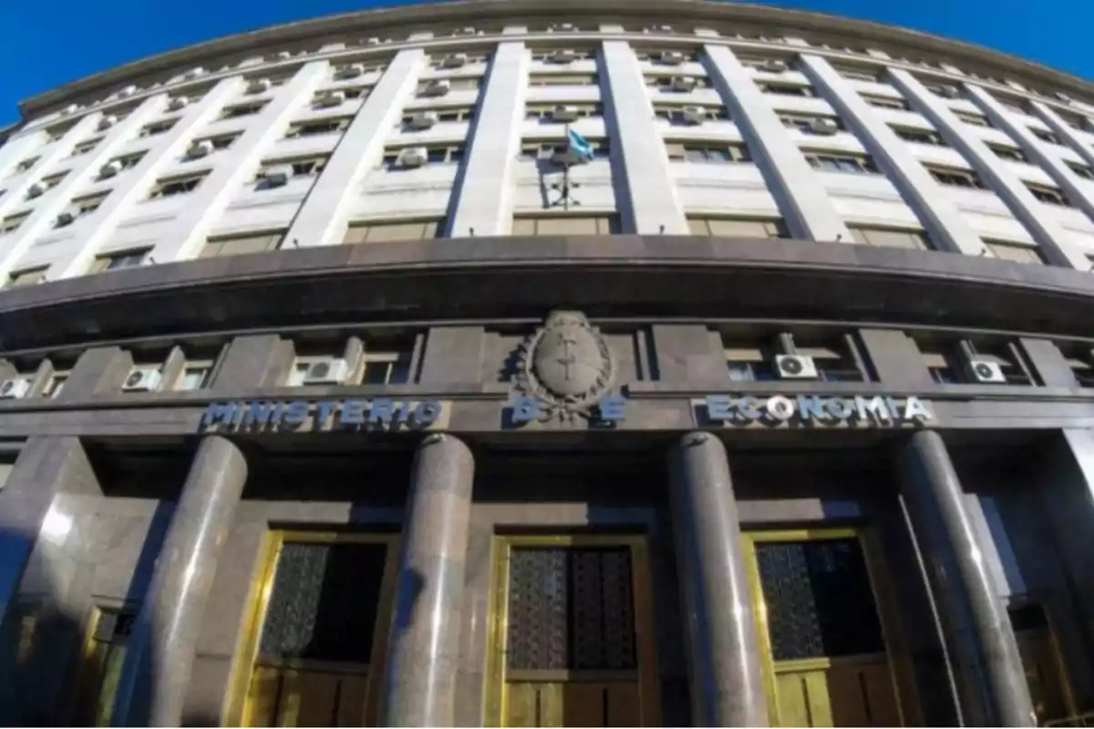 Edificio del Ministerio de Economía con fachada de columnas y bandera ondeando en la parte superior.