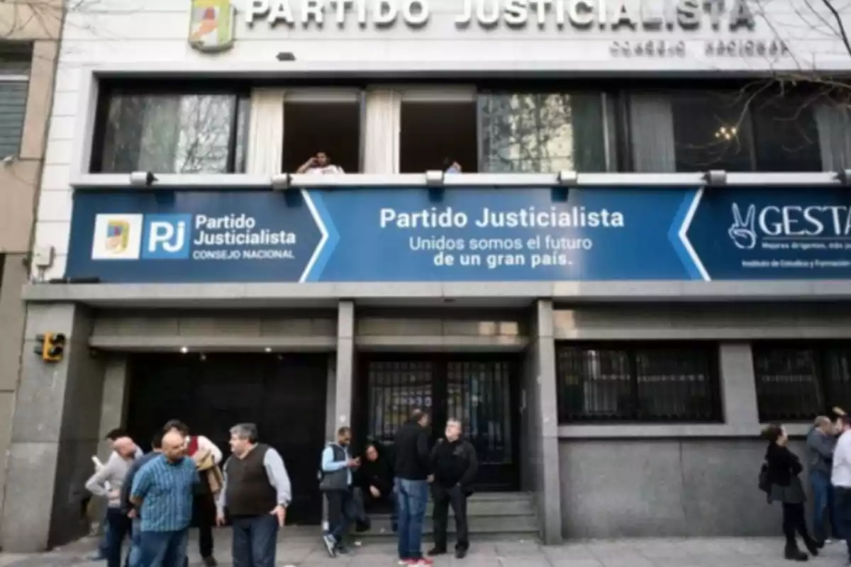 Fachada de un edificio del Partido Justicialista con personas reunidas en la entrada.