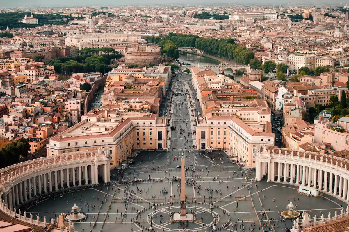 Vista aérea de una plaza monumental rodeada de edificios históricos y una ciudad extensa al fondo.