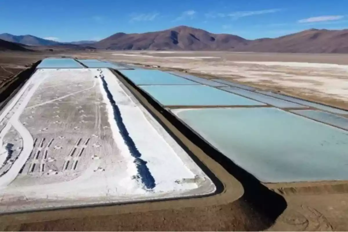 Vista aérea de una planta de extracción de litio con piscinas de evaporación en un paisaje desértico.