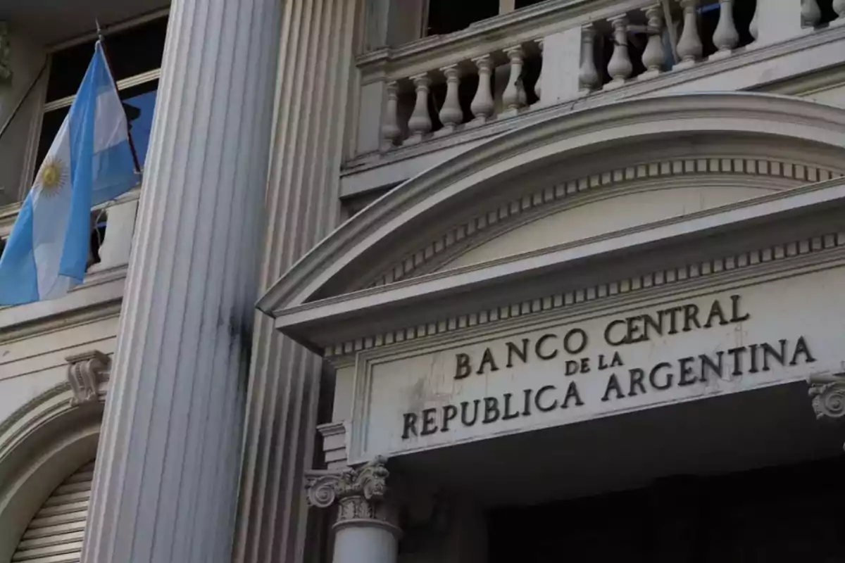 Fachada del Banco Central de la República Argentina con una bandera argentina ondeando.