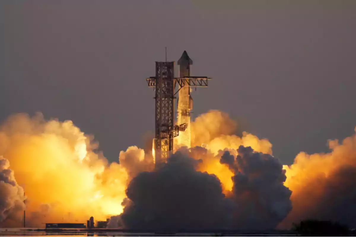 Un cohete despegando con una gran cantidad de humo y fuego en la base mientras se eleva hacia el cielo.