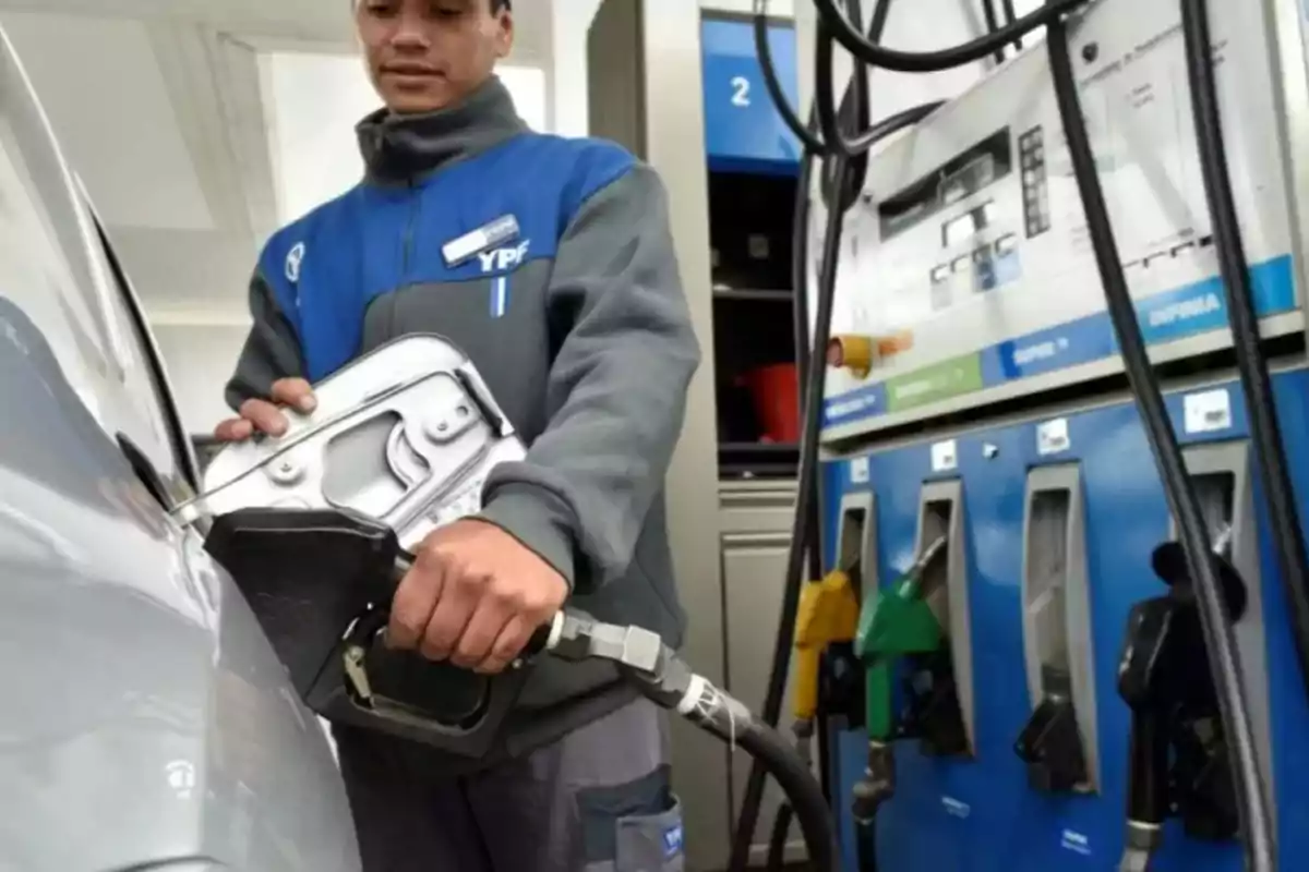 Persona llenando el tanque de un automóvil en una estación de servicio.